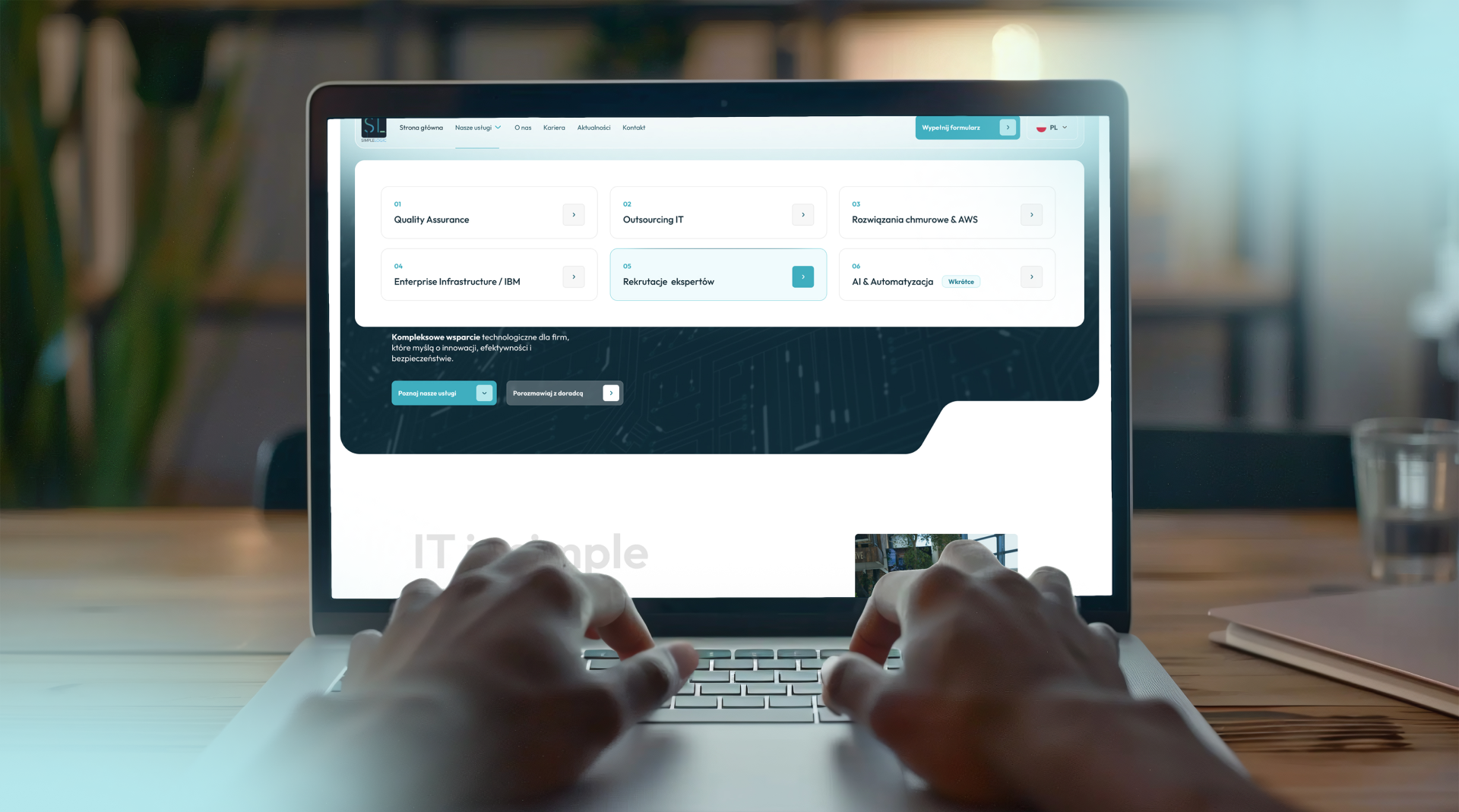 Sekcja usług SimpleLogic na ekranie laptopa z kafelkami Quality Assurance, Outsourcing IT, rozwiązania chmurowe AWS i AI oraz automatyzacja.