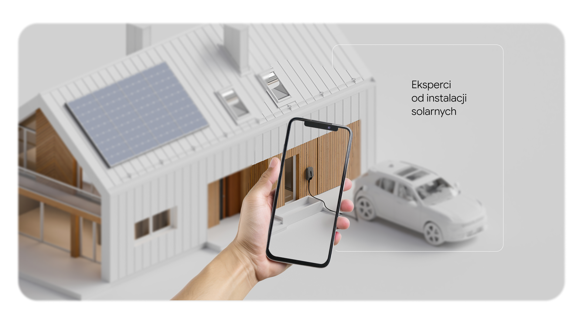 Model domu z instalacją fotowoltaiczną i ładowarką do auta elektrycznego oraz telefon w dłoni, hasło Eksperci od instalacji solarnych SOLAREOO.
